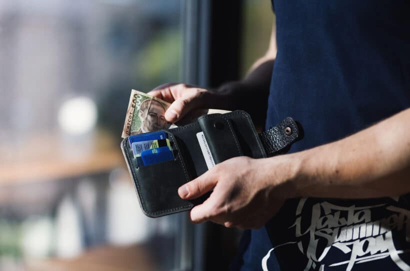 man holding a wallet with cash